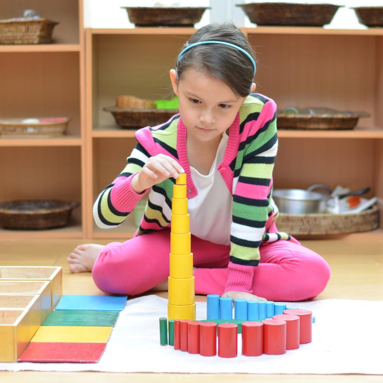 Little girl hand building tower made of blocks