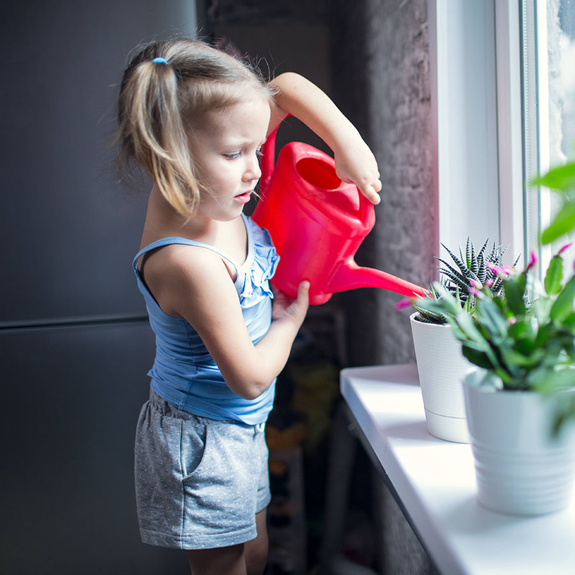 a little girl watering plants